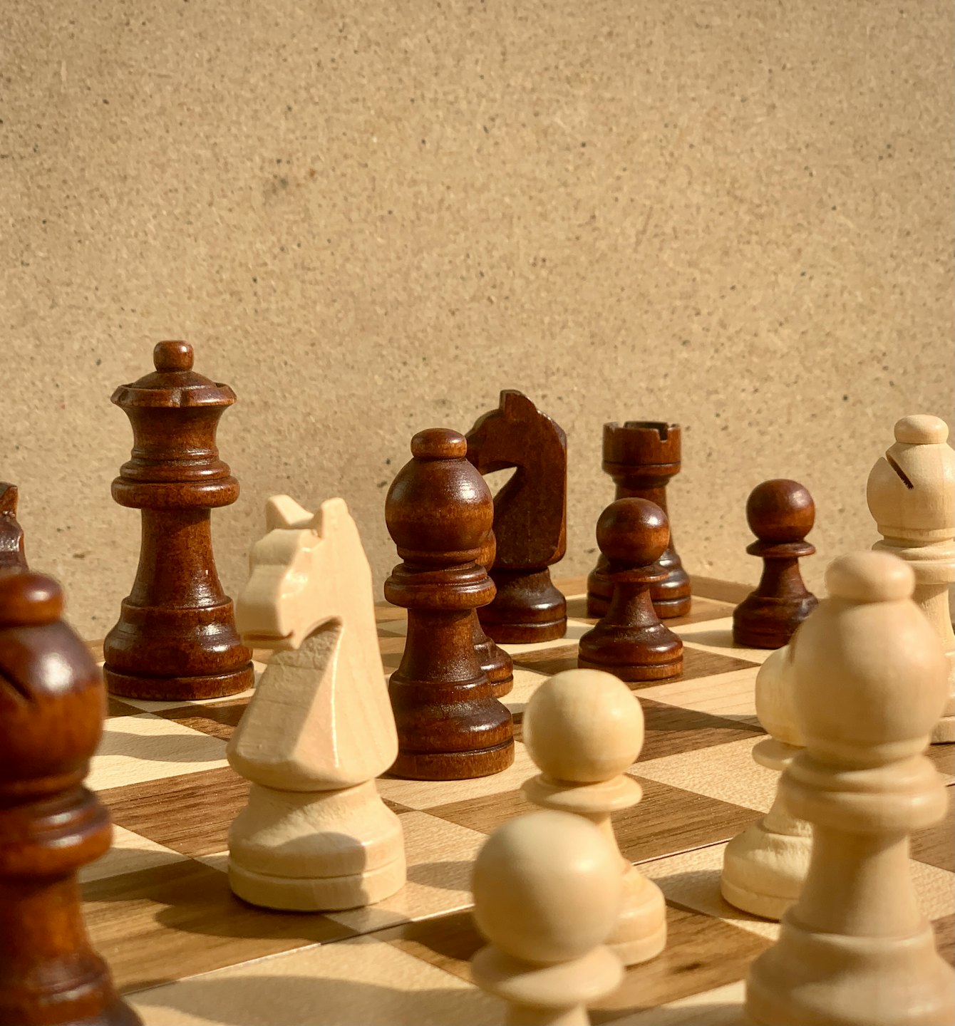 Wooden chess pieces arranged on a game board.