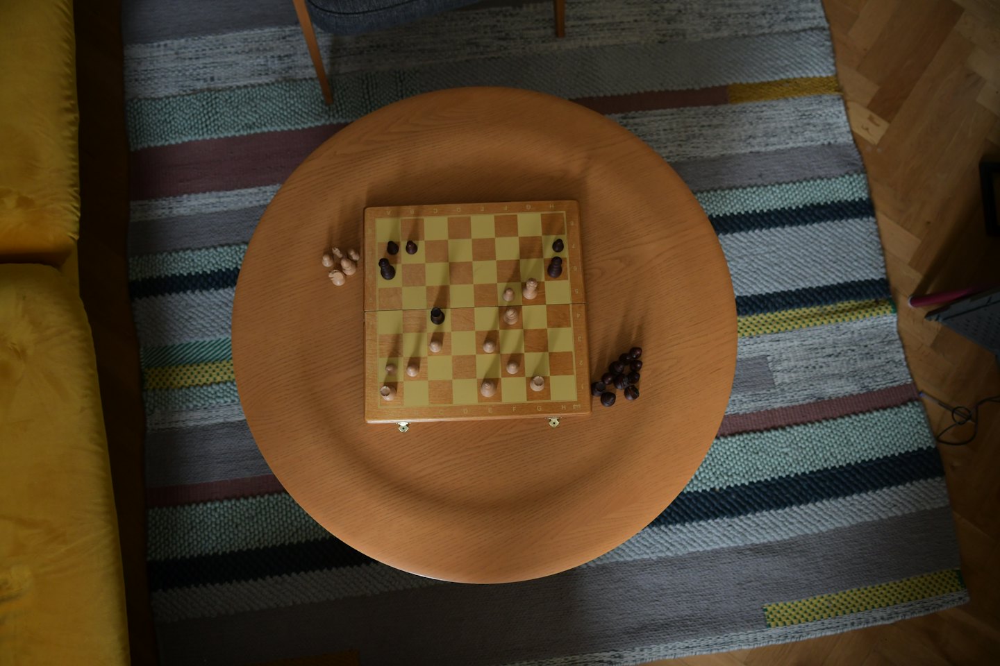 Chess game in progress on a wooden coffee table.